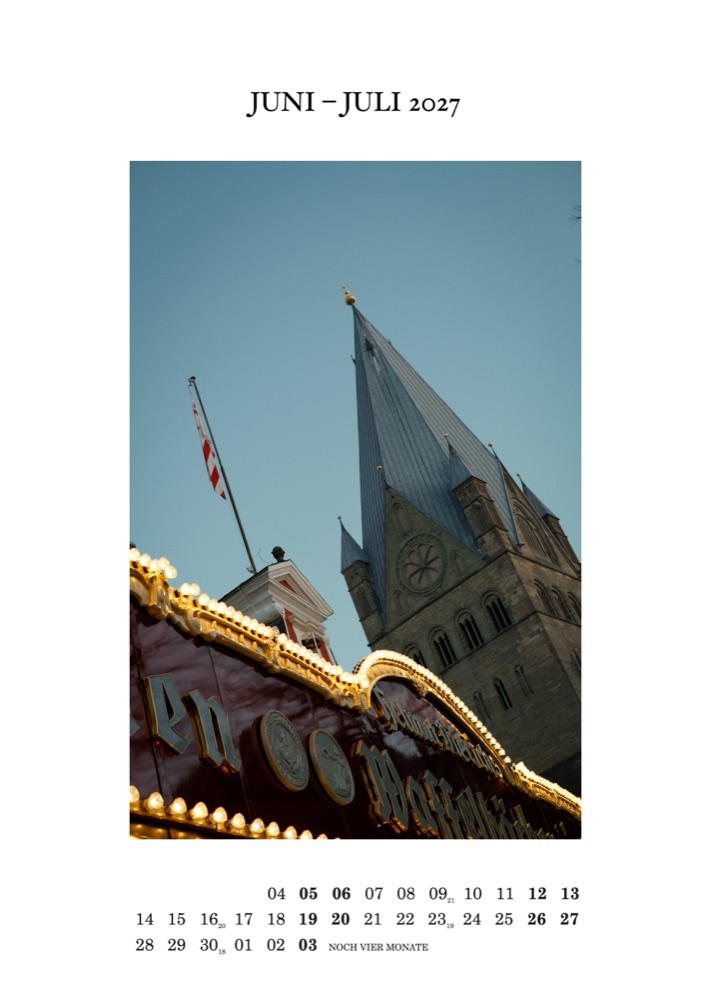 Kalenderblatt Juni – Juli 2027: Goldene Lichterkette eines Fahrgeschäfts vor dem Turm der Wiesenkirche